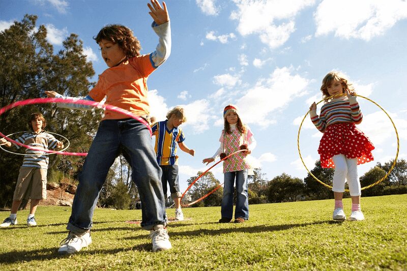 Children playing with hula hoops in the park